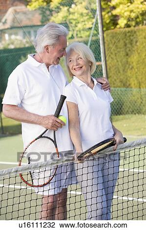 Stock Image - Couple playing tennis and smiling. Fotosearch