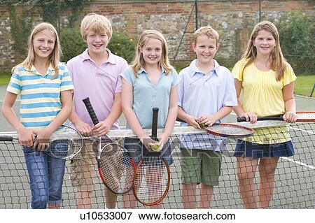 Stock Photo - Five young friends with rackets on tennis court smiling. Fotosearch