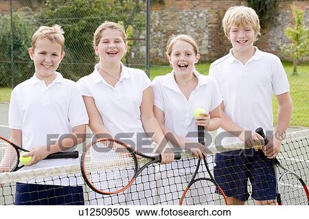 Four young friends with rackets on tennis court smiling View Large Photo Image Stock Photography - Four young friends with rackets on tennis court smiling. Fotosearch