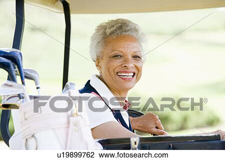 Stock Image - Portrait Of Woman Sitting In A Golf Cart. Fotosearch