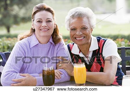 Two Female Friends Enjoying A Beverage By A Golf Course View Large Photo Image Stock Photo - Two Female Friends Enjoying A Beverage By A Golf Course. Fotosearch