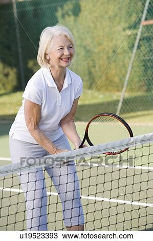 Woman playing tennis and smiling View Large Photo Image Stock Image - Woman playing tennis and smiling. Fotosearch