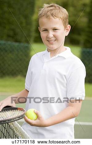 Young boy with racket on tennis court smiling View Large Photo Image Stock Photo - Young boy with racket on tennis court smiling. Fotosearch