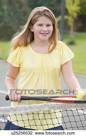 Young girl with racket on tennis court smiling View Large Photo Image Stock Image - Young girl with racket on tennis court smiling. Fotosearch