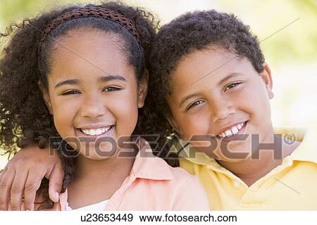 Stock Photo - Brother and sister outdoors smiling. Fotosearch