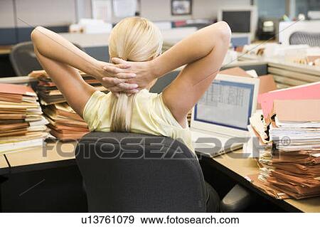 Businesswoman in cubicle with laptop and stacks of files View Large Photo Image Stock Photo - Businesswoman in cubicle with laptop and stacks of files. Fotosearch
