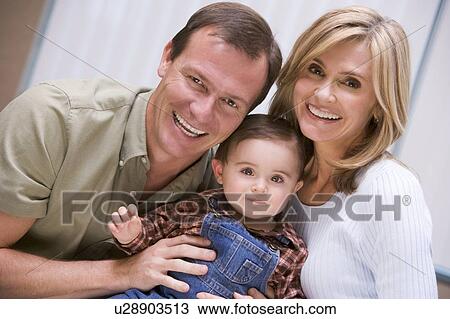 Couple indoors with baby smiling View Large Photo Image Stock Image - Couple indoors with baby smiling. Fotosearch