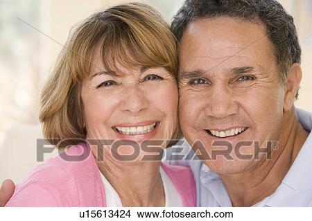 Picture - Couple relaxing in living room smiling. Fotosearch