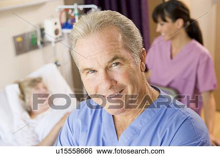 Stock Photograph - Doctor Standing In Patients Room, Nurse Checking Up On Patient. Fotosearch