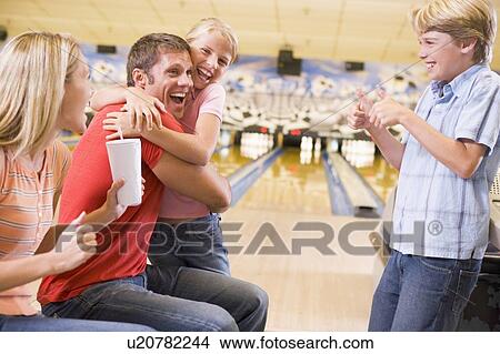 Picture - Family in bowling alley cheering and smiling. Fotosearch