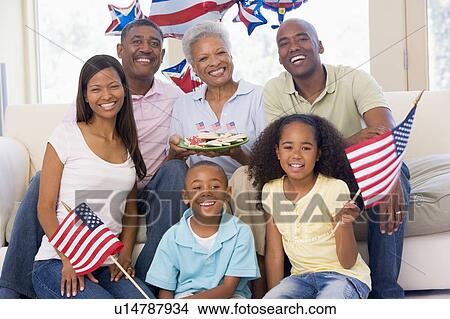 Family in living room on fourth of July with flags and cookies smiling View Large Photo Image Picture - Family in living room on fourth of July with flags and cookies smiling. Fotosearch
