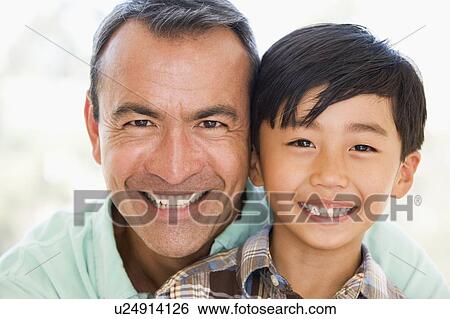 Man and young boy smiling View Large Photo Image Stock Photograph - Man and young boy smiling. Fotosearch