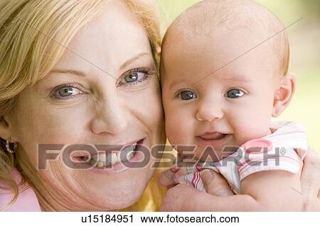 Stock Image - Mother and baby outdoors smiling. Fotosearch
