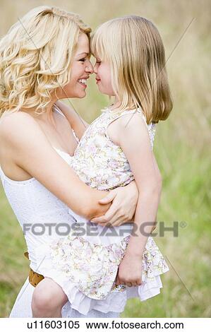 Mother holding daughter outdoors smiling View Large Photo Image Stock Photography - Mother holding daughter outdoors smiling. Fotosearch