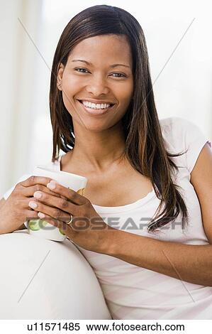 Woman in living room with coffee smiling View Large Photo Image Stock Photography - Woman in living room with coffee smiling. Fotosearch