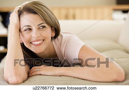 Woman lying in living room View Large Photo Image Stock Image - Woman lying in living room. Fotosearch
