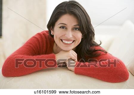 Stock Photo - Woman sitting in living room. Fotosearch