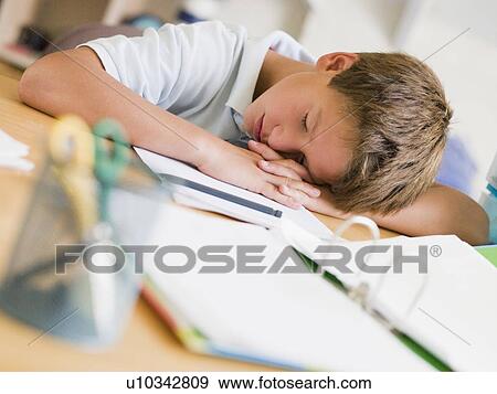 Stock Photo - Young Boy Asleep On His Schoolbooks. Fotosearch