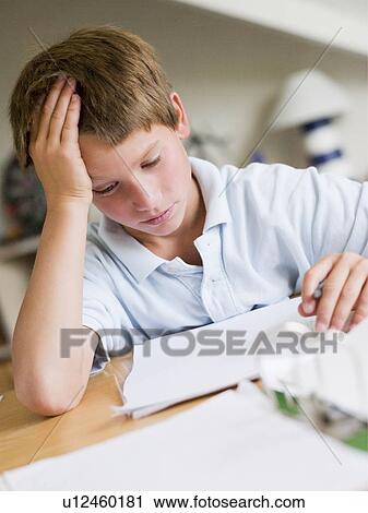 Stock Image - Young Boy Doing Homework In His Room. Fotosearch