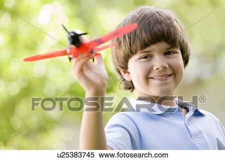 Young boy with toy airplane outdoors smiling View Large Photo Image Stock Photography - Young boy with toy airplane outdoors smiling. Fotosearch