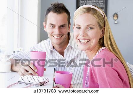 Stock Photo - Young couple having a cold drink in a cafeteria. Fotosearch