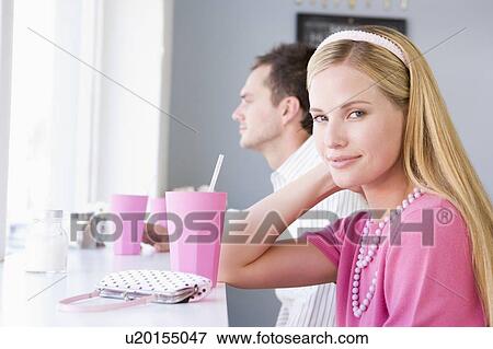 Stock Photo - Young couple having a cold drink in a cafeteria. Fotosearch