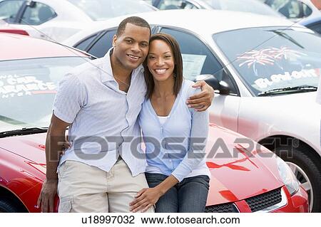 Stock Image - Young couple shopping for a new car. Fotosearch
