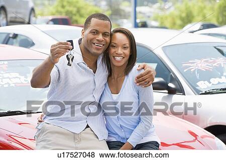 Stock Photo - Young couple shopping for a new car. Fotosearch