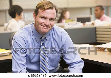 Businessman in cubicle smiling View Large Photo Image Stock Photography - Businessman in cubicle smiling. Fotosearch