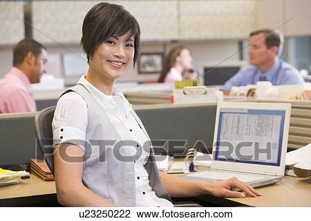 Businesswoman in cubicle smiling View Large Photo Image Stock Image - Businesswoman in cubicle smiling. Fotosearch