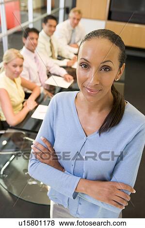 Businesswoman with four businesspeople at boardroom table in background View Large Photo Image Stock Photo - Businesswoman with four businesspeople at boardroom table in background. Fotosearch