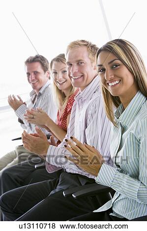 Four businesspeople applauding indoors smiling View Large Photo Image Stock Photo - Four businesspeople applauding indoors smiling. Fotosearch