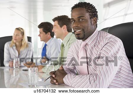 Four businesspeople in a boardroom smiling View Large Photo Image Stock Image - Four businesspeople in a boardroom smiling. Fotosearch