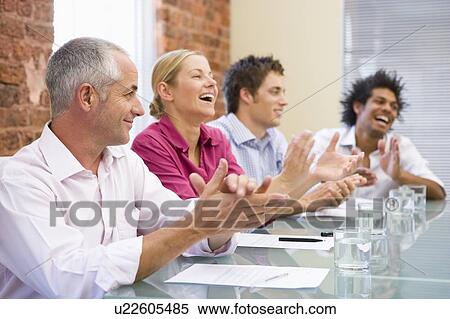 Four businesspeople in boardroom applauding and smiling View Large Photo Image Stock Photography - Four businesspeople in boardroom applauding and smiling. Fotosearch