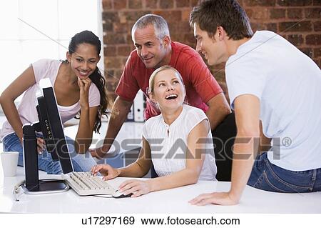 Four businesspeople in office space with computer smiling View Large Photo Image Stock Photo - Four businesspeople in office space with computer smiling. Fotosearch