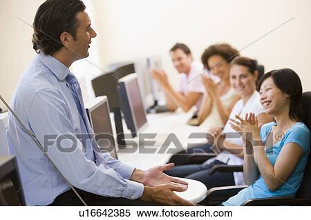 Stock Photography - Man giving lecture in applauding computer class. Fotosearch