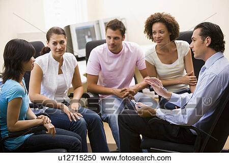 Man giving lecture to four people in computer room View Large Photo Image Stock Image - Man giving lecture to four people in computer room. Fotosearch