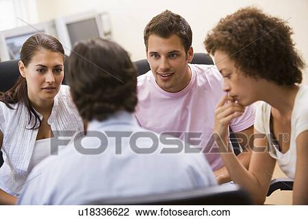 Man giving lecture to three people in computer room View Large Photo Image Stock Image - Man giving lecture to three people in computer room. Fotosearch