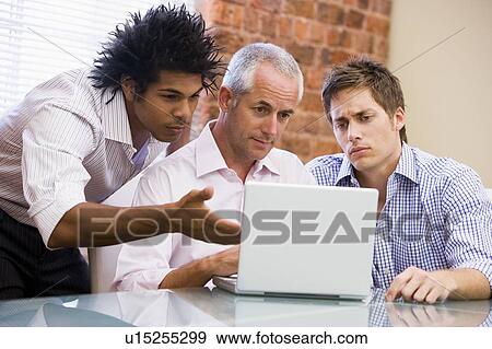 Three businessmen sitting in office with laptop View Large Photo Image Stock Photo - Three businessmen sitting in office with laptop. Fotosearch