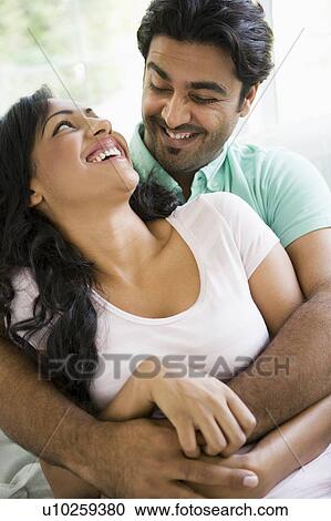 Couple in living room embracing and smiling (high key) View Large Photo Image Stock Image - Couple in living room embracing and smiling (high key). Fotosearch