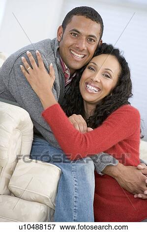 Stock Photo - Couple in living room smiling. Fotosearch