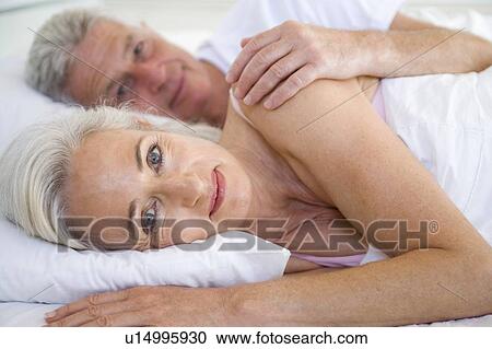 Couple lying in bed together smiling View Large Photo Image Stock Image - Couple lying in bed together smiling. Fotosearch