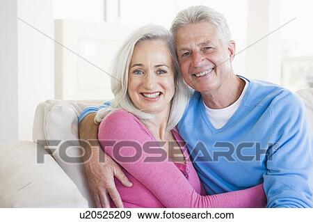 Stock Photo - Couple relaxing in living room and smiling. Fotosearch