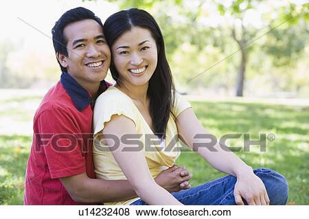 Couple sitting outdoors smiling View Large Photo Image Stock Photo - Couple sitting outdoors smiling. Fotosearch