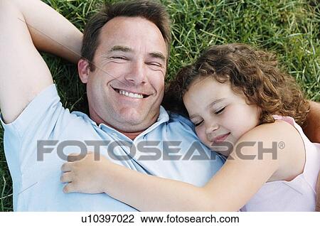 Father and sleeping daughter lying outdoors smiling View Large Photo Image Stock Image - Father and sleeping daughter lying outdoors smiling. Fotosearch