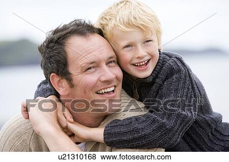 Stock Photo - Father and son at beach smiling. Fotosearch