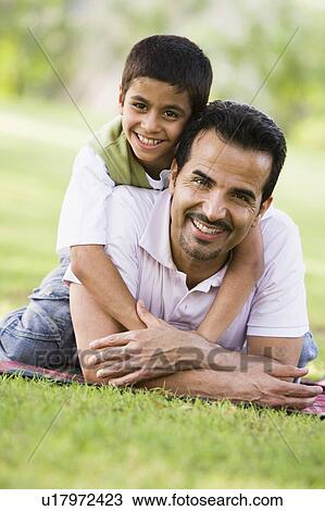 Father and son outdoors in park embracing and smiling (selective focus) View Large Photo Image Stock Image - Father and son outdoors in park embracing and smiling (selective focus). Fotosearch