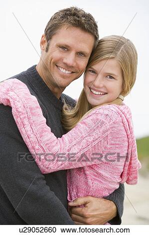 Father holding daughter at beach smiling View Large Photo Image Stock Image - Father holding daughter at beach smiling. Fotosearch