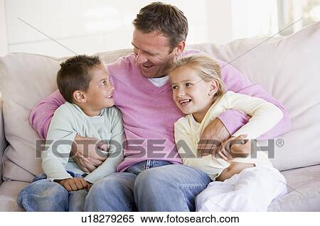 Man and two children sitting in living room smiling View Large Photo Image Stock Photography - Man and two children sitting in living room smiling. Fotosearch