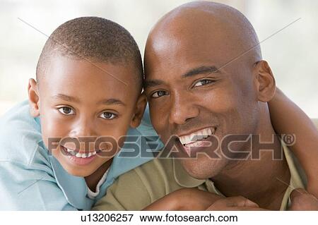 Man and young boy embracing and smiling View Large Photo Image Stock Photo - Man and young boy embracing and smiling. Fotosearch